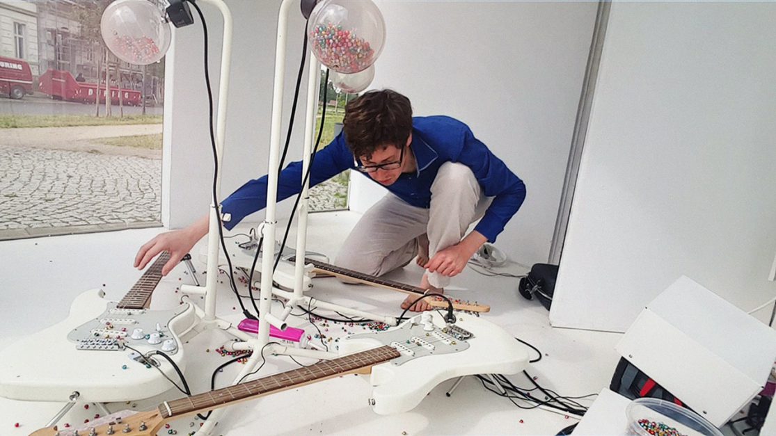 Martin Hiller setting up his installation "fünftausend bimmeln" for 5000 small bells drip-dropping on three guitars